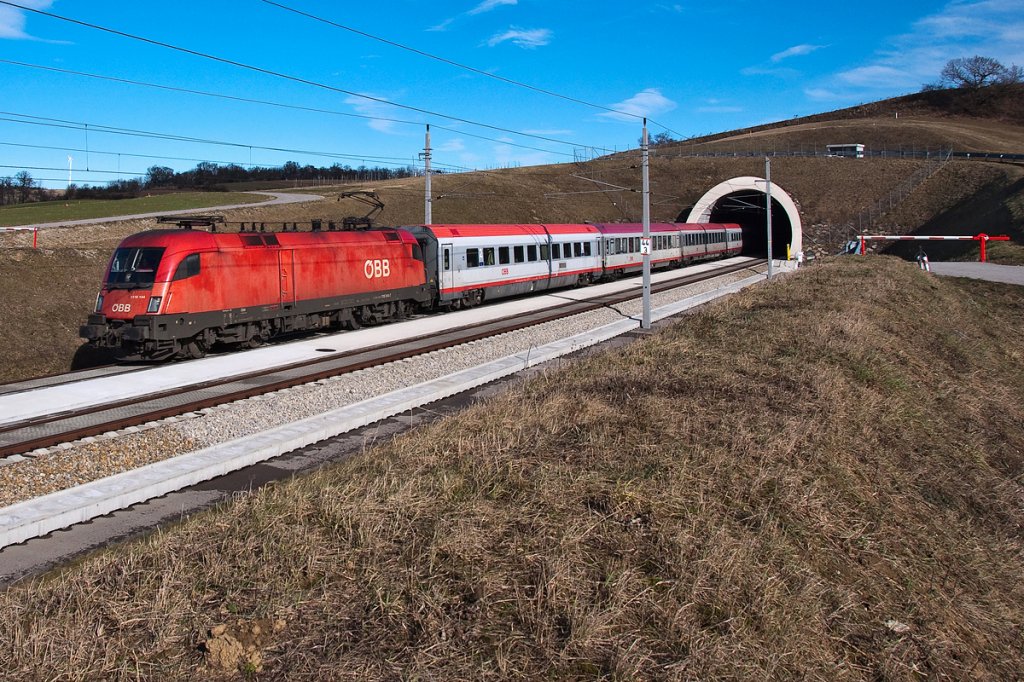 1116 144 hat soeben mit dem OIC 864 den 1307 Meter langen Reisenbergtunnel in Richtung St. Plten verlassen. Die Aufnahme entstand am 03.02.2013 an der NBS bei Perschling.
