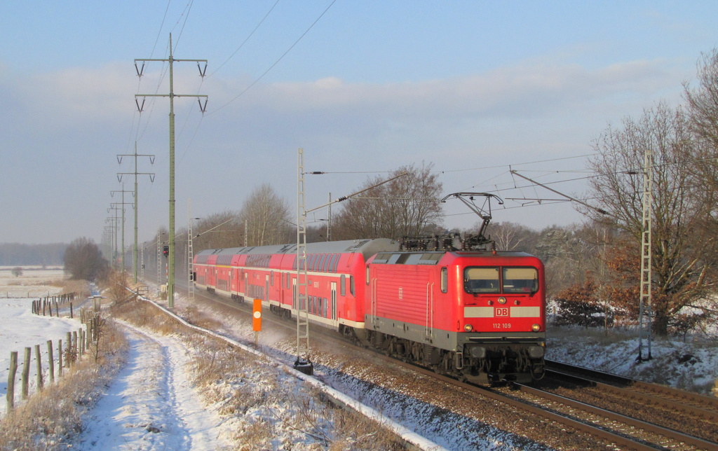 112 109 kommt hier mit einer RE5 Garnitur durch Diedersdorf. Die Lok schleppt die Garnitur nach Lichtenberg oder Cottbus um dort den Steuerwagen reparieren zu lassen. 03.02.2012
