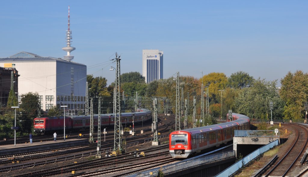 112 173-0 und ein Triebzug BR474 in Hamburg Hbf mit Messeturm und SAS Radisson Hotel im Hintergrund. (22.10.2011)