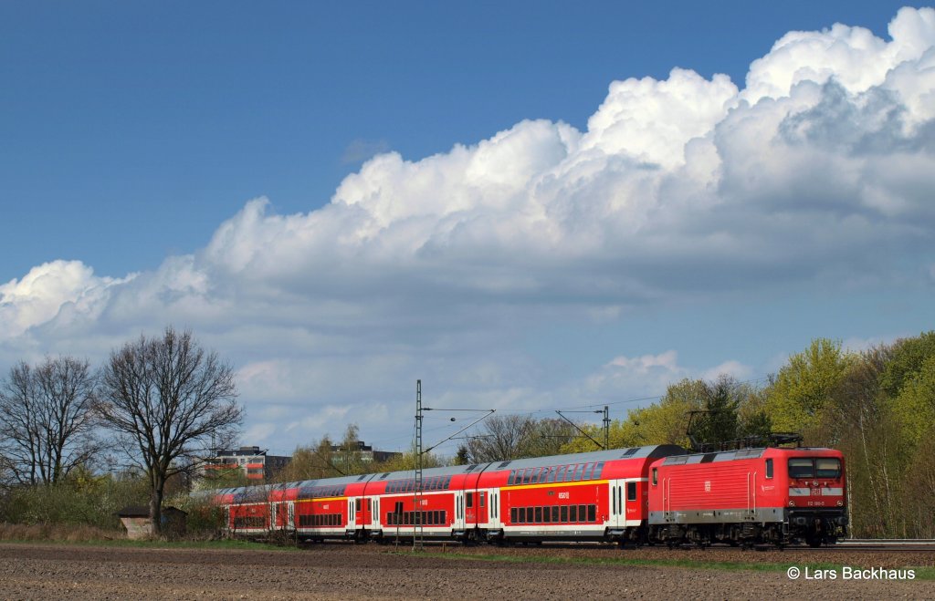 112 180-5 passiert am 17.04.11 mit einem RE von Kiel nach Hamburg die Halstenbeker Baumschule.