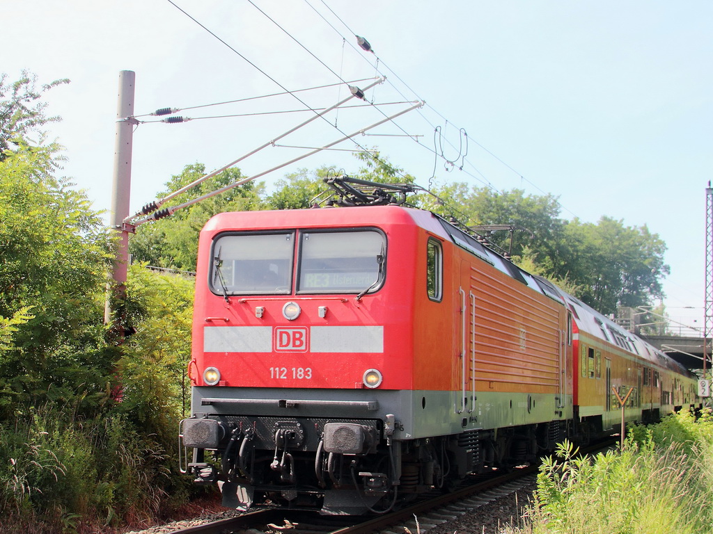 112 183 mit dem RE 3 nach Elsterwerder passiert am 17. Juni 2013 den Bahnbergang Tunnelweg in Blankenfelde (Bandenburg) kurz vor dem Bahnhof Blankenburg.