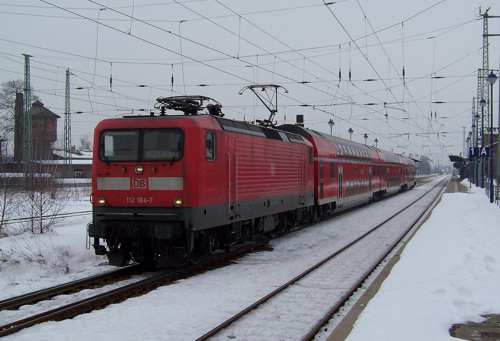 112 184-7 mit einem RE2 von Berlin Gesundbrunnen nach Cottbus ber Vetschau, bei der Ausfahrt aus dem Bahnhof von Lbbenau/Spreewald. 23.01.2010