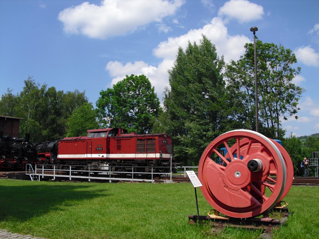112 516-0 sonnte sich auf der Drehscheibe in Schwarzenberg am 05.06.11. Im vordergrund steht das Treibrad der 58 436.