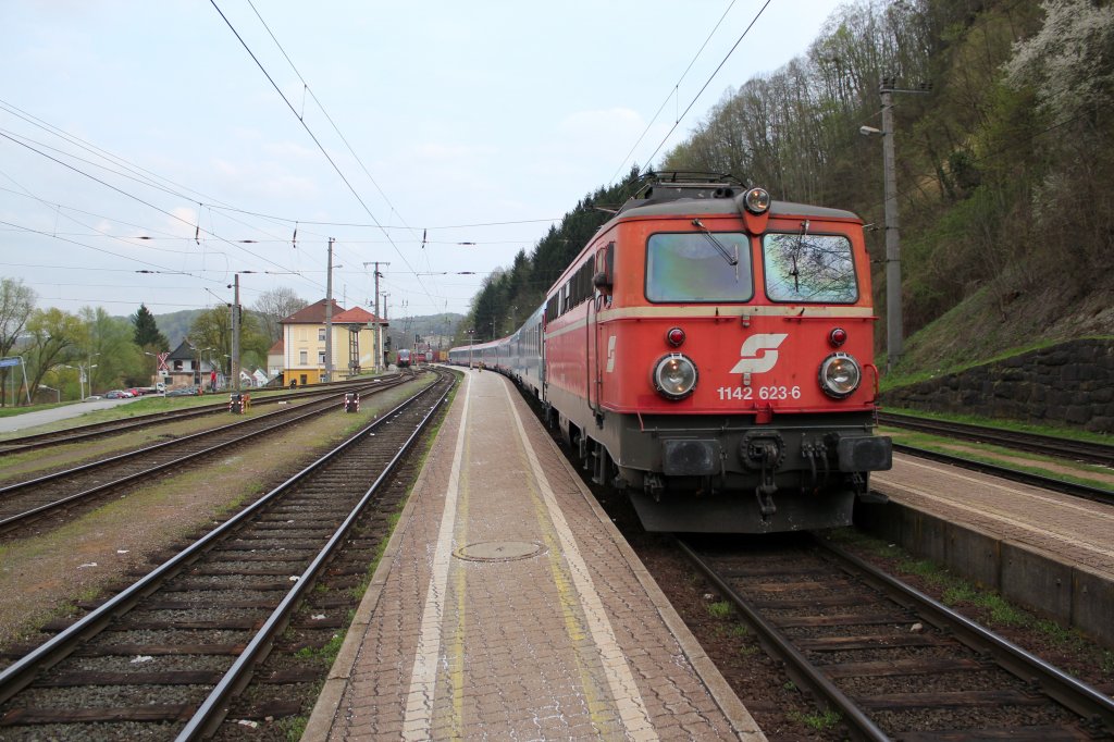1142 623 6 hat die Ehre den EC 150 (Ljubljana - Wien Meidling) von Spielfeld Strass nach Wien Meidling zu ziehen. Der Lokwechsel an der Grenze  /Slo wurde gerade vollzogen und nun geht es nach kurzem Halt weiter Richtung Graz, April 2013
Im Hintergrund vor dem Bahnhofsgebude sieht man auch einen Regionalzug von Bad Radkersburg kommend, der rechtzeitig ankam um Reisende den Umstieg in den Zug Richtung Graz zu ermglichen.