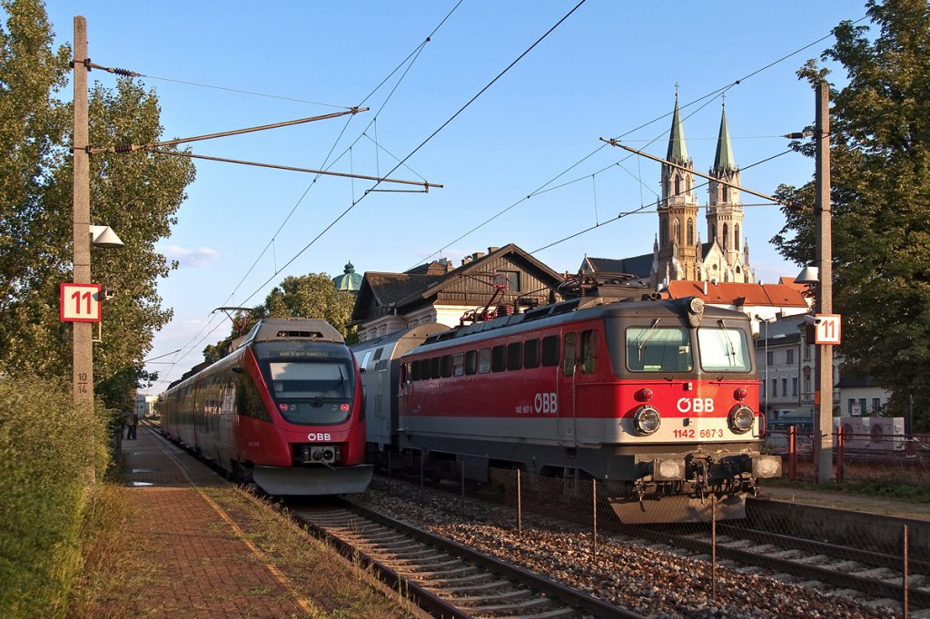 1142 667 ist mit R 2180 von Wien FJB nach Sigmundsherberg unterwegs, whrend 4124 031 als S Bahn Linie 40 aufgrund von Bauarbeiten nur bis Klosterneuburg-Weidling fhrt. Die Aufnahme entstand am 22.07.2011 in Klosterneuburg-Kierling.