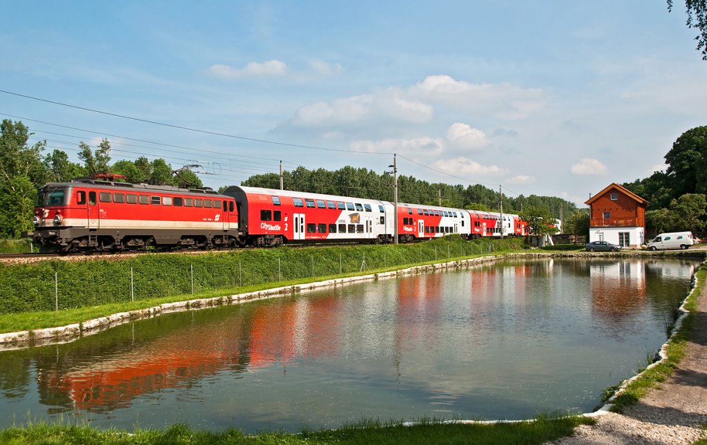 1142 668 mit R 7164 (Wien - Krems/Donau) spiegelt sich im Fischteich kurz vor Kritzendorf. Die Aufnahme entstand am 28.05.2010.
