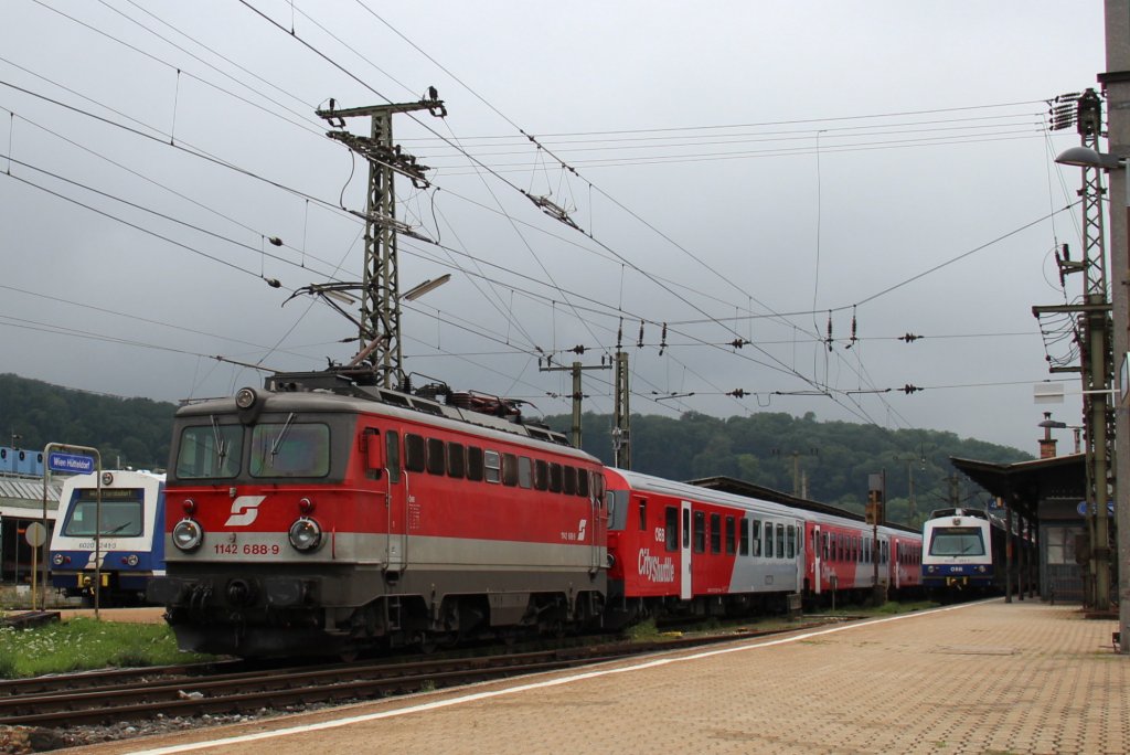 1142 688 schleppte den R 2027 von Sankt Plten Hauptbahnhof (Pb) nach Wien Westbahnhof (Ws), hier zum sehn bei der Ausfahrt des Bahnhof Wien Htteldorf (Hf); am 25.07.2012