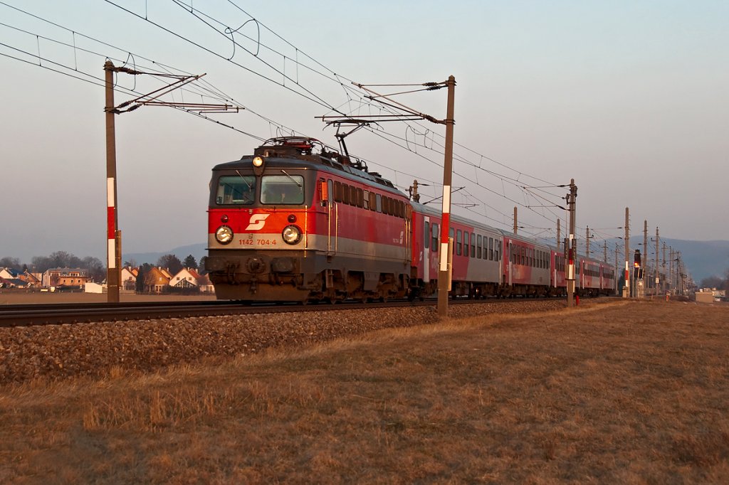 1142 704 ist im Abendlicht mit REX 2174 von Wien nach Sigmundsherberg unterwegs. Die Aufnahme entstand am 04.03.2011 kurz vor Langenlebarn.