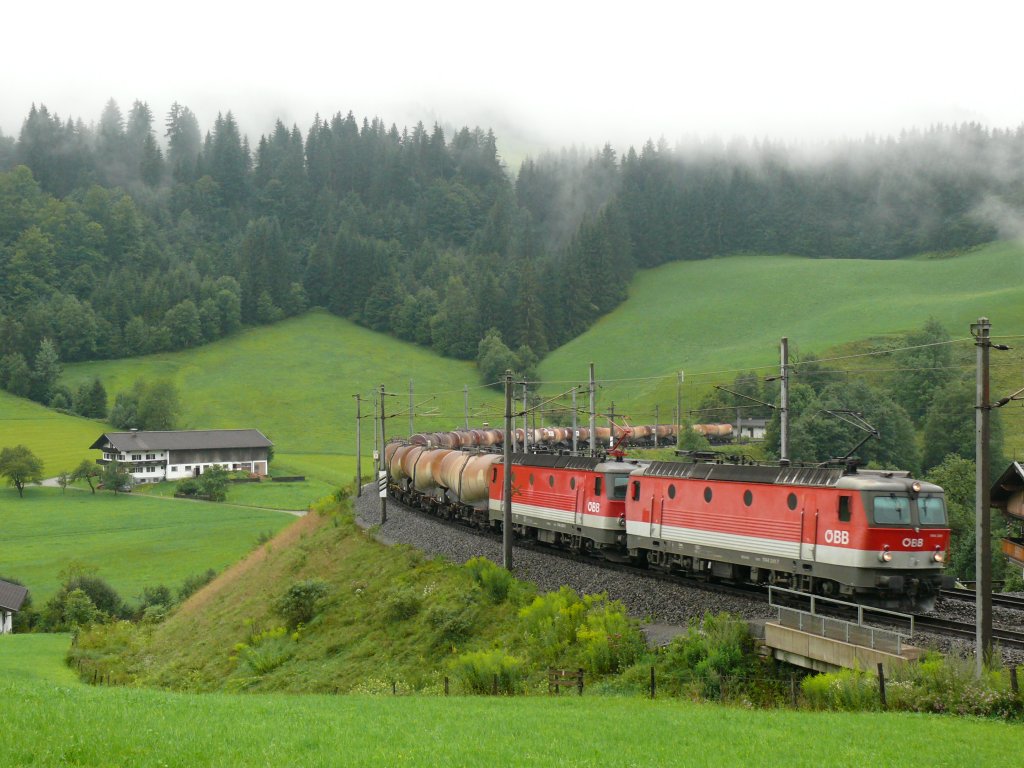 1144 241-7 und 1144 225-0 ziehen in Doppeltraktion einen langen Kesselwagenzug durchs Brixental, hier in der 180 Gradkehre zwischen Hopfgarten und Westendorf. Aufgenommen am 06/08/2010.