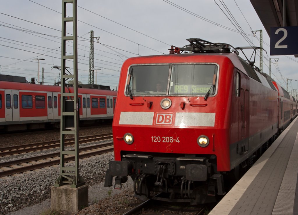 120 208-4 ist am 11.04.2011 mit RE 9 (Rhein-Sieg-Express) nach Siegen in den Bahnhof Troisdorf eingefahren.