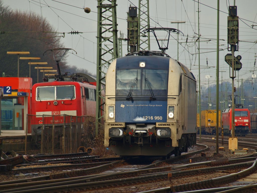 1216 950 der Wiener Lokalbahnen GmbH am 13.12.2010 als Lz unterwegs in Aachen West. Die Lok hat einen Autozug aus Richtung Kln kommend auf Gleis 14 abgehangen, fhrt nun zum Aachener Hbf und wird dort auf Gleis 11 abgestellt. An dem Autozug hngt schon eine Cobra um ihn nach Belgien zu schleppen. Links im Bild 111 146-7 mit dem RE4 am Bahnsteig, rechts 152 109-5 mit einem Containerzug.