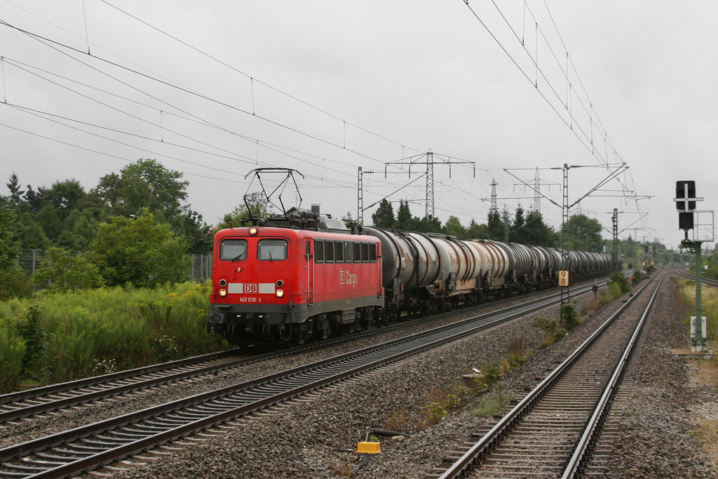 140 018 mit einem Kesselwagenzug am nassen 05.08.2010 in Mnchen-Langwied. (Bild vom S-Bahnsteig gemacht)