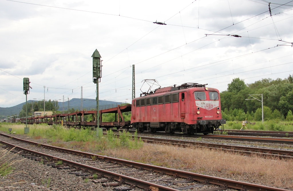140 024-1, die mehr und mehr einen bedauernswerten Anblick bietet, kam am 16.06.2011 mit leeren Autotransportwagen in Richtung S�den durch Eschwege West.