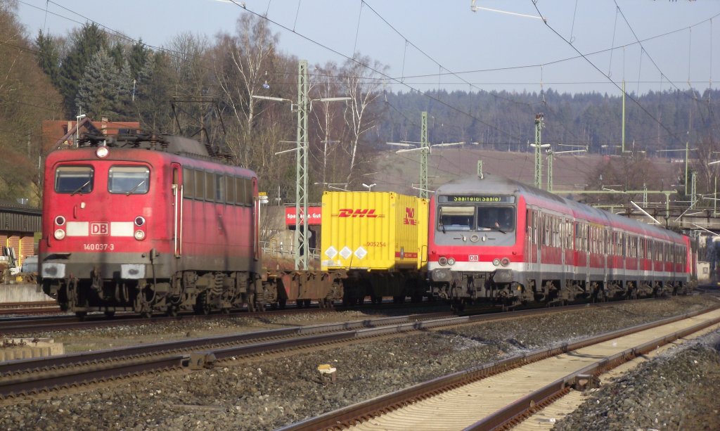 140 037-3 mit einem DHL-Containerzug und eine RB nach Saalfeld begegnen sich am 11. Dezember 2011 im Gleisvorfeld von Kronach.