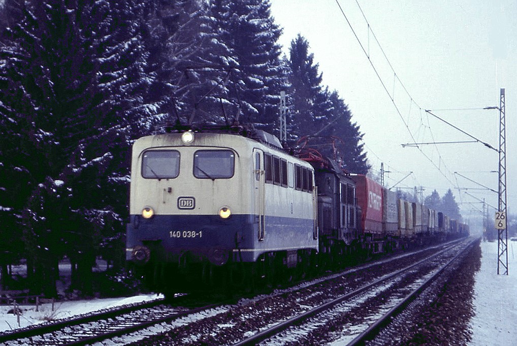 140 038 und 194 084 sind bei Prien in Richtung Salzburg unterwegs, 12.01-1985.