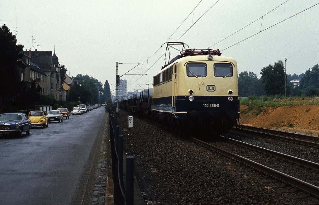 140 265-0 1980 in Düsseldorf-Grafenberg. Die Verbindung von Duisburg-Wedau nach Köln-Mülheim zählt mit ca. 200 Güterzügen pro Tag zu den am dichtesten befahrenen Güterzugstrecken der DB und trennte durch ihre zahlreichen niveaugleichen Bahnübergänge bis zur Eröffnung des rd. 2 km langen Staufenplatz-Tunnels am 02.08.1982 die östlichen Düsseldorfer Stadtteile von der City. Rechts von der Lok ist ein Stück der Tunneldecke zu sehen. Heute befindet sich auf der Bahntrasse eine Grünanlage.
