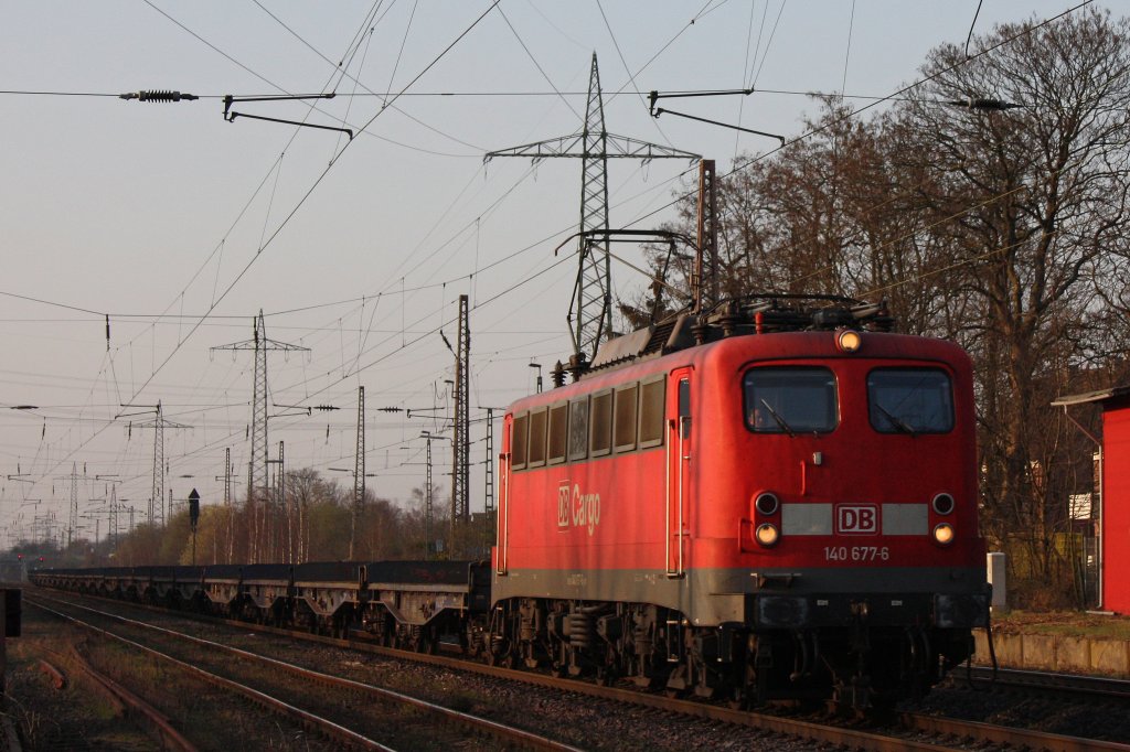 140 677 am 23.3.12 mit einem Flachwagenzug durch Ratingen-Lintorf.
