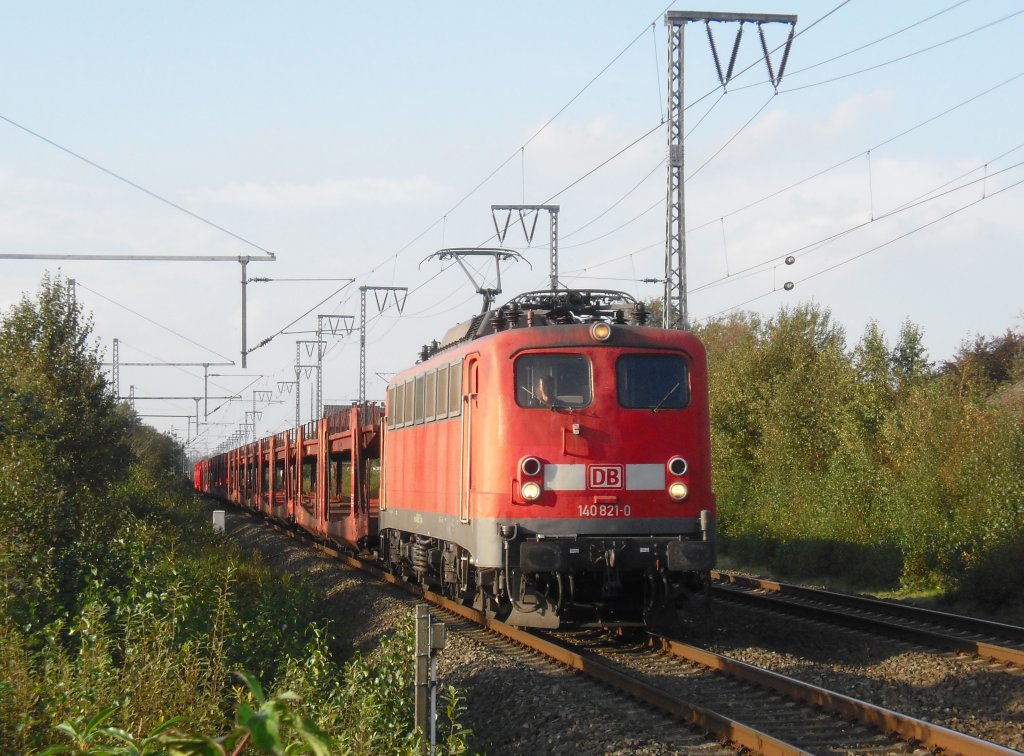 140 821-0 fuhr im Oktober 2011 mit einem Gterzug gen Sden, hier in Neermoor.
