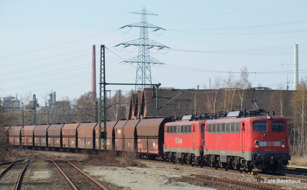 140 857-4 und 140 810-3 kommen mit einem fetten Kohlenbomber von Hamburg-Hansaport kommend durch Hamburg-Unterelbe Richtung Hamburg-Harburg. Aufgenommen am 07.04.10 beim passieren eines alten Lokschuppens.