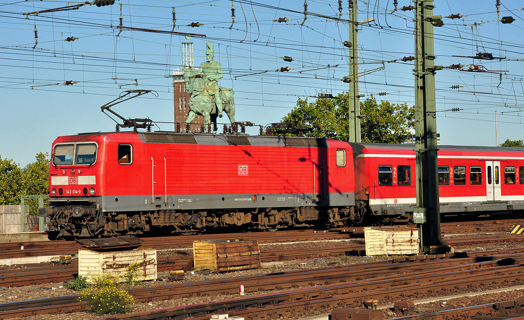143 014-9 S6 nach Essen, zwischen Hbf Kln und Hohenzollernbrcke, im Hintergrund Reiterstatue und Messeturm Kln-Deutz - 10.10.2010