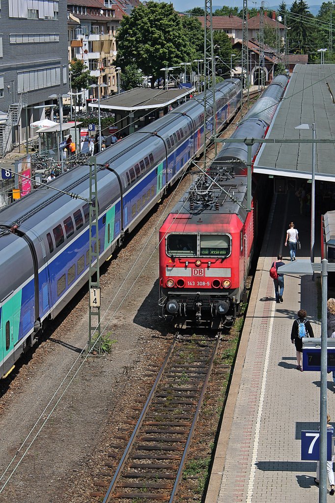 143 308-5 zusammen mit einer Schwesterlok am Zugende auf Gleis 7 in Freiburg (Brsg) Hbf. Links zu sehen, TGV 4714 (310 027-2/310 028-0) bei der Prsentation auf Gleis 8.