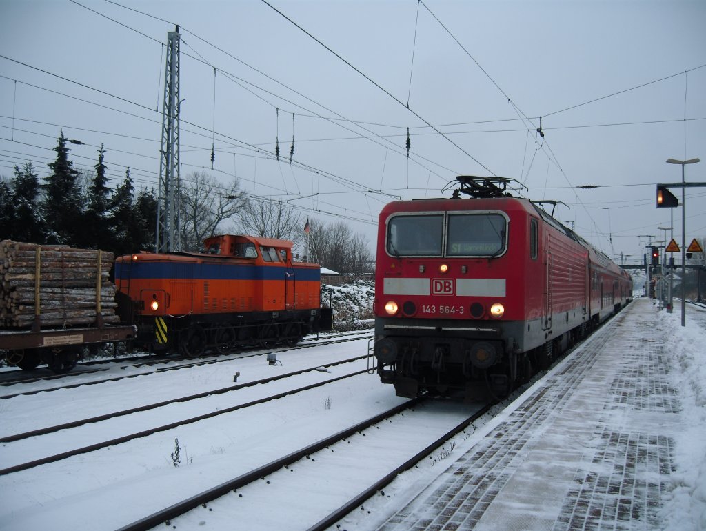 143 564 mit der S1 nach Warnemnde in Rostock-Bramow. Nebenan ist die V60 der Rostocker Fracht- und Fischereihafen (RFH) Hafenbahn gerade mit dem Verschub eines Holzzuges beschftigt.
12.01.2010