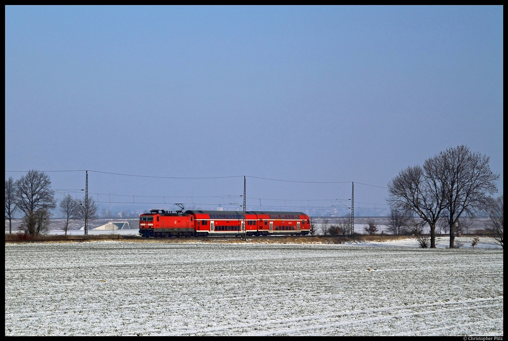 143 585-8 zieht am 12.2.2012 nahe Priestewitz eine RB aus Elsterwerda gen Dresden. Im Hintergrund verluft die Neubaustrecke Weiig - Bhla.