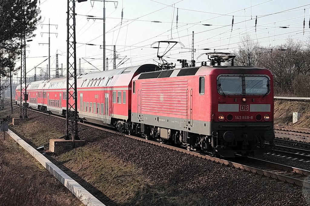 143 868-8 mit einem Regionalzug der Linie RB 7 (RE 18723) von Blankenfelde(Teltow-Flming) nach Berlin Schnefeld Flughafen passiert am 16. Februar 2011 den Ort Mahlow.