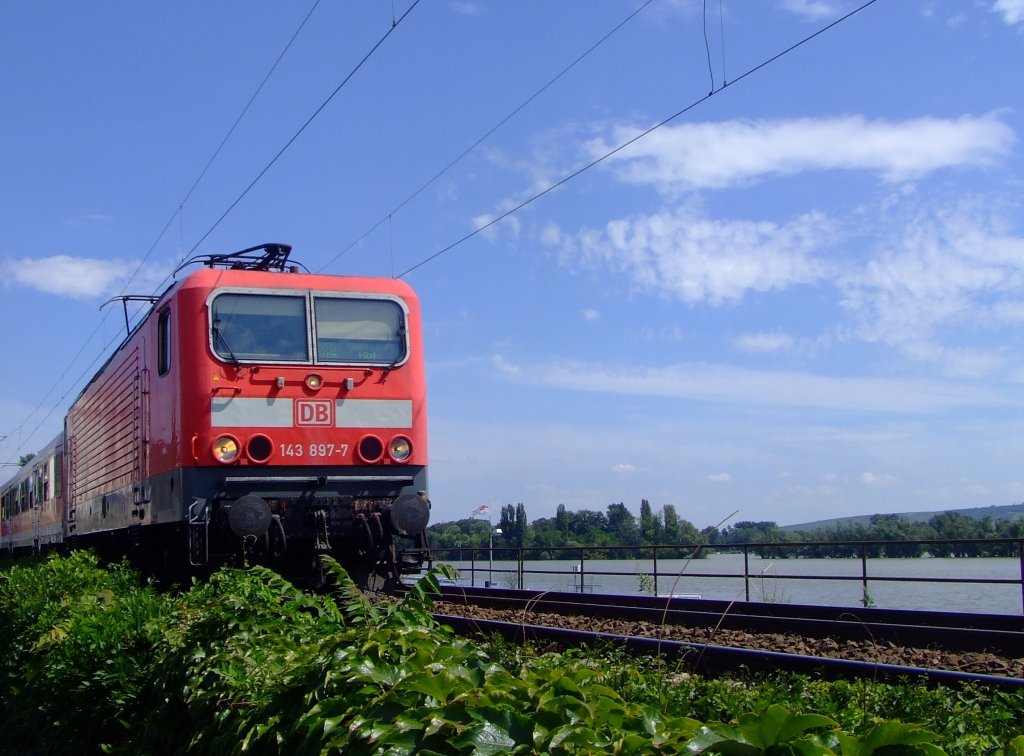 143 897-7 mit Nahverkehrszug am 26.07.2007 in Rdesheim am Rhein. Die 143 er ist die ehem. DR-Baureihe 243 und wurden bei Lokomotivbau Elektrotechnische Werke in Hennigsdorf gebaut. Die Loks haben eine Dauerleistung von 3500 kW.