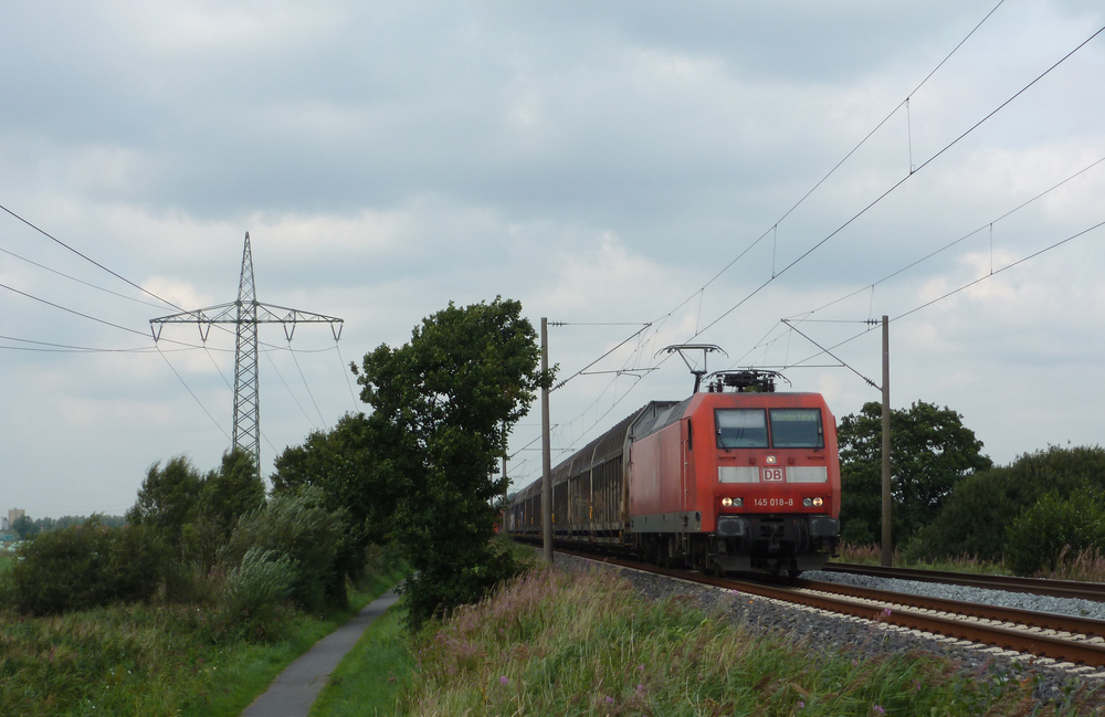 145 018-8 fuhr am 28.08.2012 mit einem Gterzug von Emden nach Osnabrck, hier sdlich von Leer.