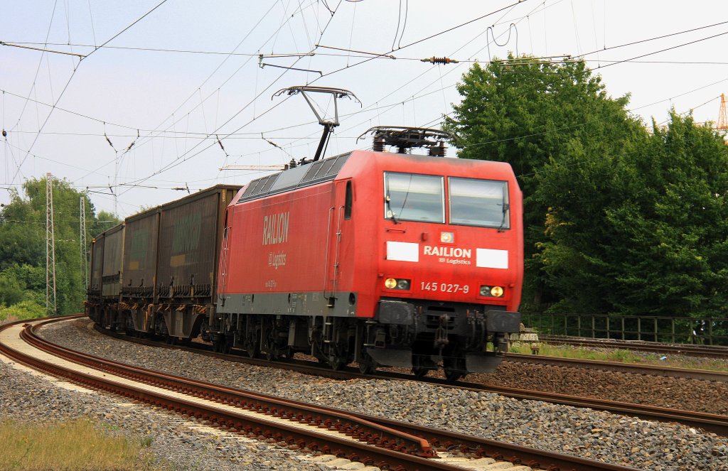 145 027-9 von Railion kommt durch Eschweiler-Hbf mit einem Lkw-Ambrogio-Ganzzug aus Richtung Kln und fhrt nach Aachen-West bei Sommerwetter mit Wolken am 21.8.2012.
