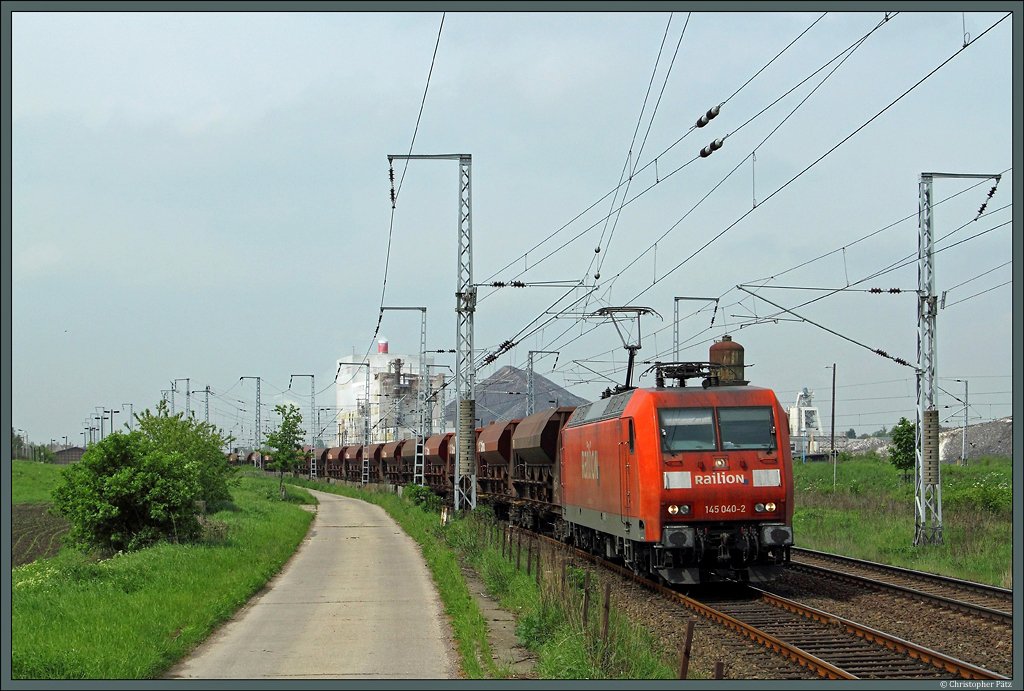 145 040-2 mit einem Sch�ttgutwagenzug im Bahnhof Teutschenthal. Im Hintergrund das ehemalige Kaliwerk Teutschenthal, das heute als Versatzbergwerk dient. (16.05.2013)