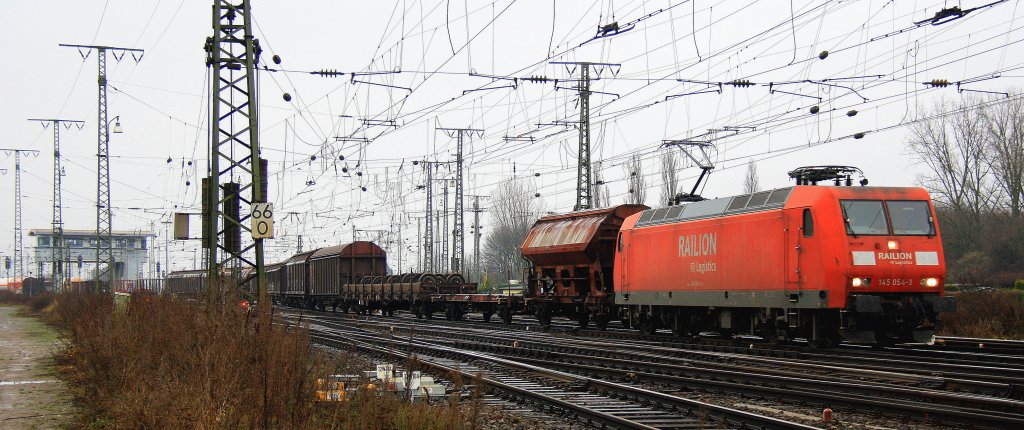 145 054-3  von Railion fhrt mit einem gemischten Gterzug aus Kln-Gremberg und fhrt in Richtung Kln-Sd bei der Abfahrt aus Kln-Gremberg bei Nieselregen am 21.12.2012.