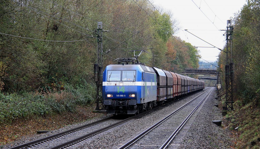 145 086-5 von NIAG kommt durch Salmtal mit einem langen Kohlenleerzug aus Neunkirchen(an der Saar) nach Moers(Gbf) und fhrt in Richtung Koblenz bei Regenwetter am 3.11.2012.