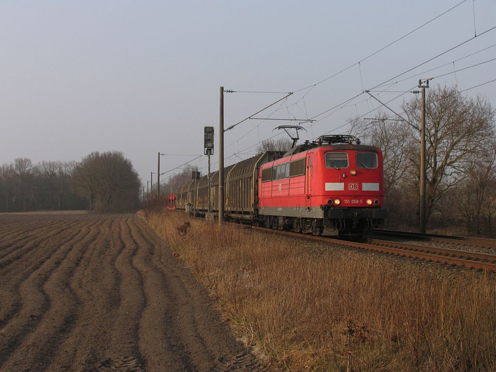 151 058-5 mit einem Gterzug zwischen Emden und Rheine bei Devermhlen am 16-3-2012.