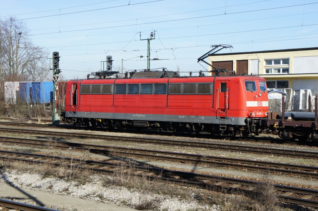 151 093-2 wartet am 15.03.11 mit einem mit Stahlbrammen beladenen Gterzug auf Ausfahrt aus Mnchen-Trudering.