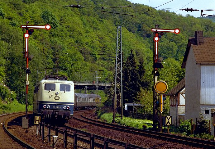 151 100 passiert mit einen Nahverkehrszug nach Siegen den an der Strecke Dillenburg - Ewersbach gelegenen Hp. Dillenburg Kurpark am 25.051987.