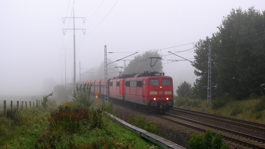151 166-6 und eine weitere Schwester erreichen im nun mehr dicken Nebel des 11.10. den Glasower Damm. Auf ihrer Umleitungsstrecke kann man die groen Erzzge wesentlich besser ablichten.