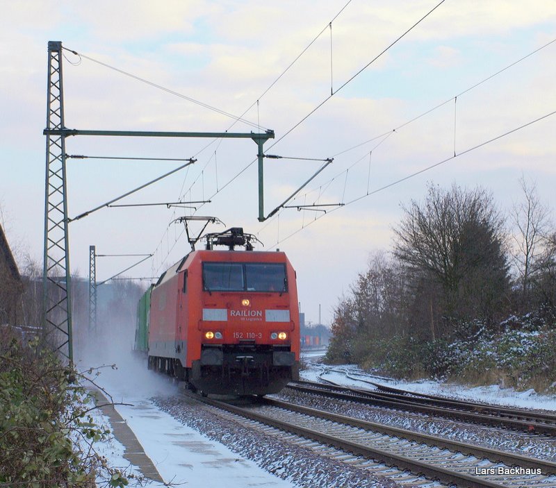 152 110-3 ist am 20.12.09 mit einem Containerzug nach Hamburg-Waltershof auf der Unterelbbahn Richtung Hafen unterwegs und wirbelt mchtig Schnee auf.
