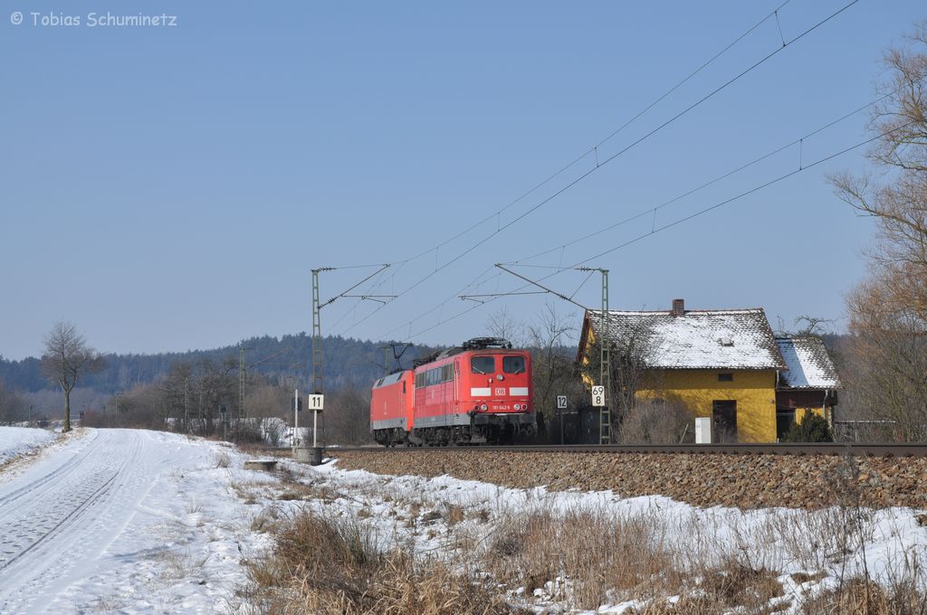 152 125 schleppt am 11.02.2012 die 151 042 am alten Bahnw�rterhaus bei P�lling in Richtung N�rnberg.