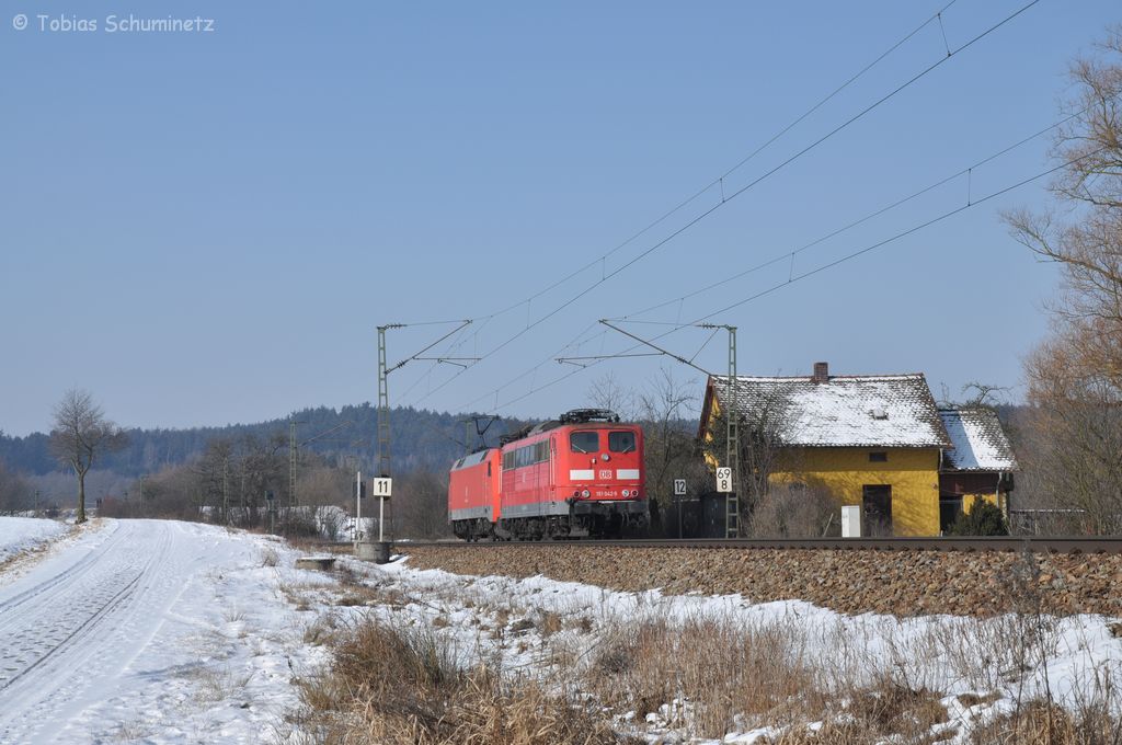 152 125 schleppt am 11.02.2012 die 151 042 am alten Bahnwrterhaus bei Plling in Richtung Nrnberg.