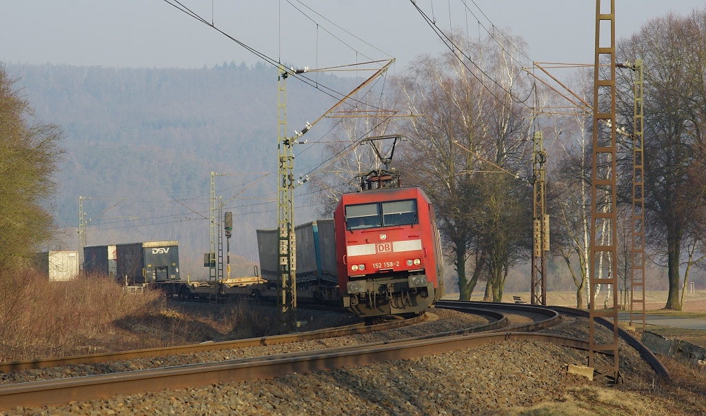 152 158-2 legt sich mit ihrem Aufliegerzug in Fahrtrichtung Sden vor Eschwege West in die Kurve. Aufgenommen am 03.03.2011.