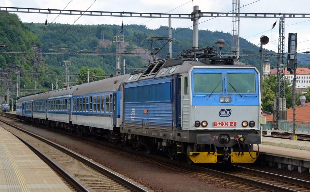 162 038 beschleunigt mit einem Regionalzug nach Prag am 04.07.13 aus Decin heraus.