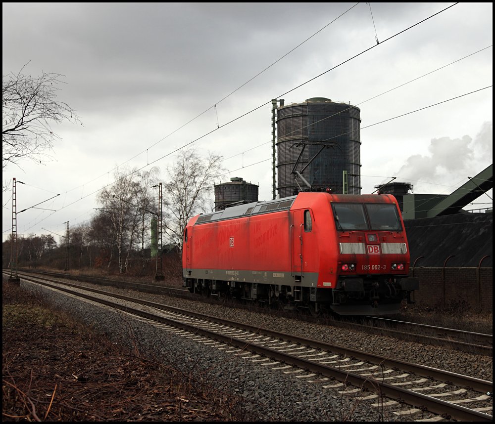 185 002 (9180 6185 002-3 D-DB) ist solo bei der Kokerei Prosper in Richtung Oberhausen unterwegs. Rechts im Bild steigt eine Qualmwolke ber dem Lschturm auf.... (24.02.2010)

