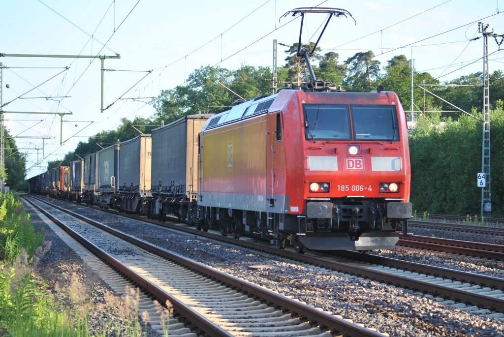 185 006-4 durchfhrt mit Containerwagen den Bahnhof von Dreieich-Buchschlag am Abend des 22.06.2012.