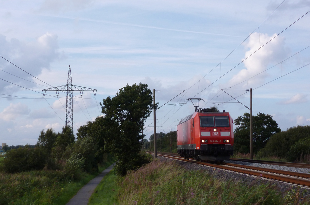 185 074-2 fuhr am 22.08.2012 als Lokzug von Emden nach Drpen, hier sdlich von Leer.