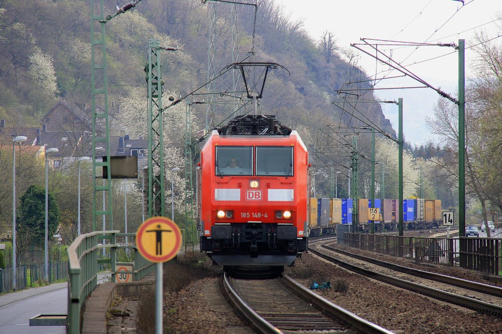 185 148-4 DB kommt durch Leubsdorf am Rhein mit einem Contanierzug aus Richtung Koblenz und fhrt nach Aachen-West ber Kln bei Sonnenschein am 3.4.2012.