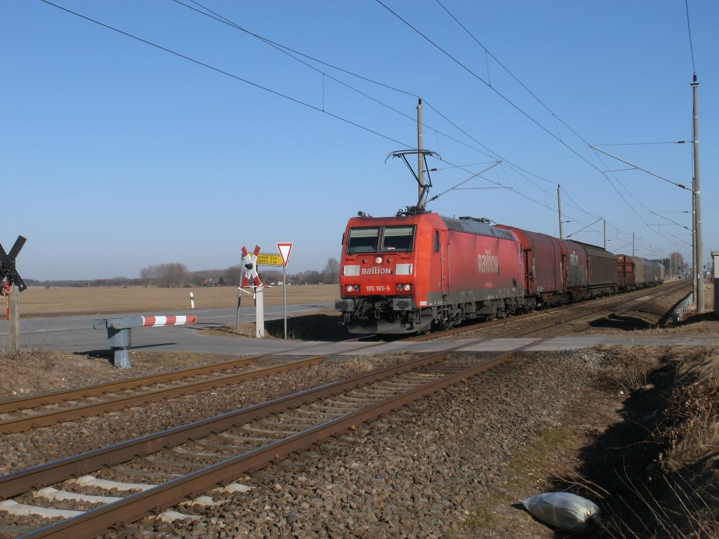 185 185-6 rauschte am 08.Mrz 2011 an einem Bahnbergang bei Rambin vorbei.