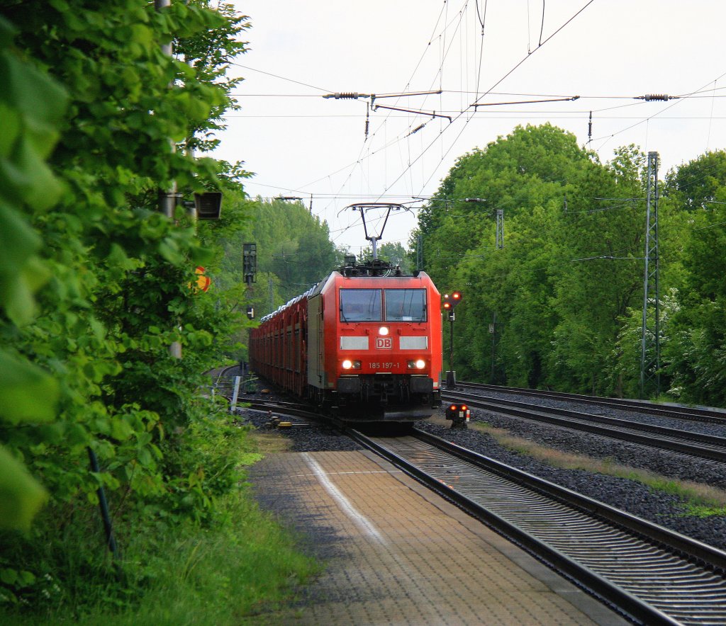185 197-1 DB kommt aus Richtung Aachen-West und fhrt durch Kohlscheid mit einem  sehr langen Toyota-Autozug aus Zeebrugge-Ramskapelle(B) nach Mszczonow(PL)  und fhrt in Richtung Herzogenrath,Neuss bei Sonne und Regenwolken am 25.5.2013.