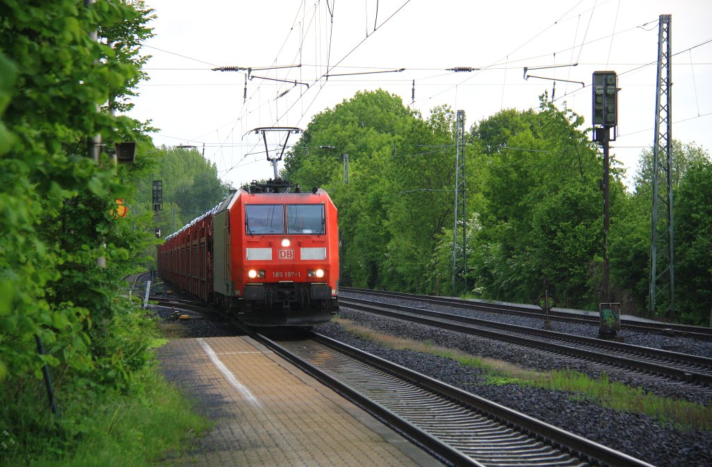185 197-1 DB kommt aus Richtung Aachen-West und fhrt durch Kohlscheid mit einem sehr langen Toyota-Autozug aus Zeebrugge-Ramskapelle(B) nach Mszczonow(PL) und fhrt in Richtung Herzogenrath,Neuss bei Sonne und Regenwolken am 25.5.2013.